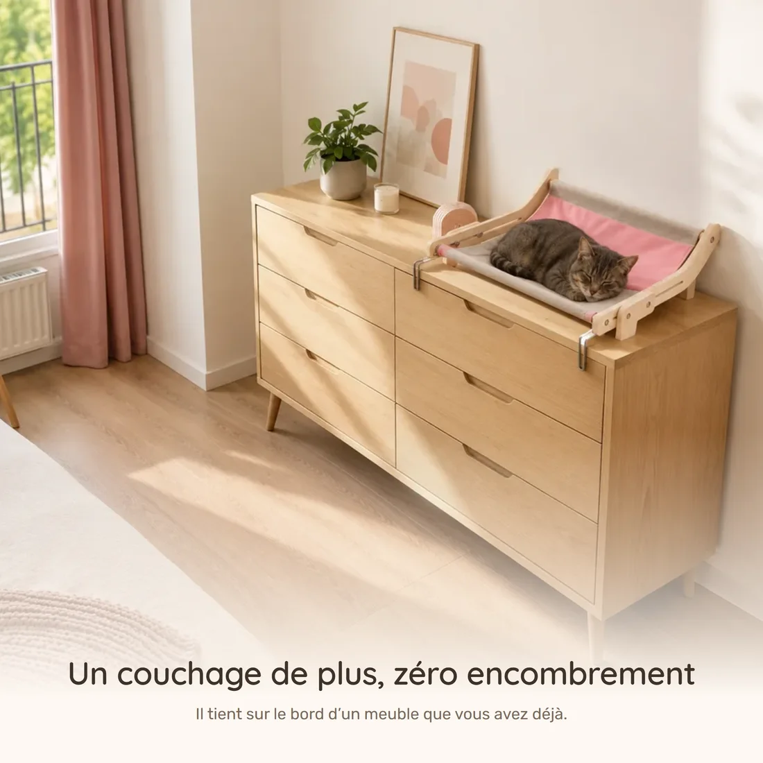 Un couchage de plus, zéro encombrement — le hamac à cadre bois clipsé sur une commode, un chat endormi, le sol dégagé